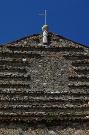 Gornji dio pročelja  župne crkve svetog Servula s kipom evanđelista iz 13. stoljeća