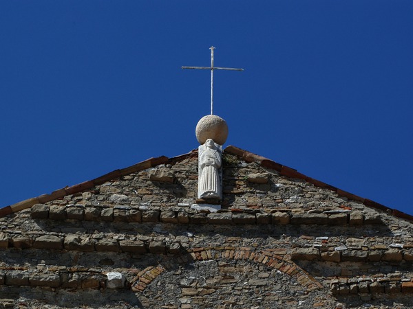Gornji dio pročelja  župne crkve svetog Servula s kipom evanđelista iz 13. stoljeća